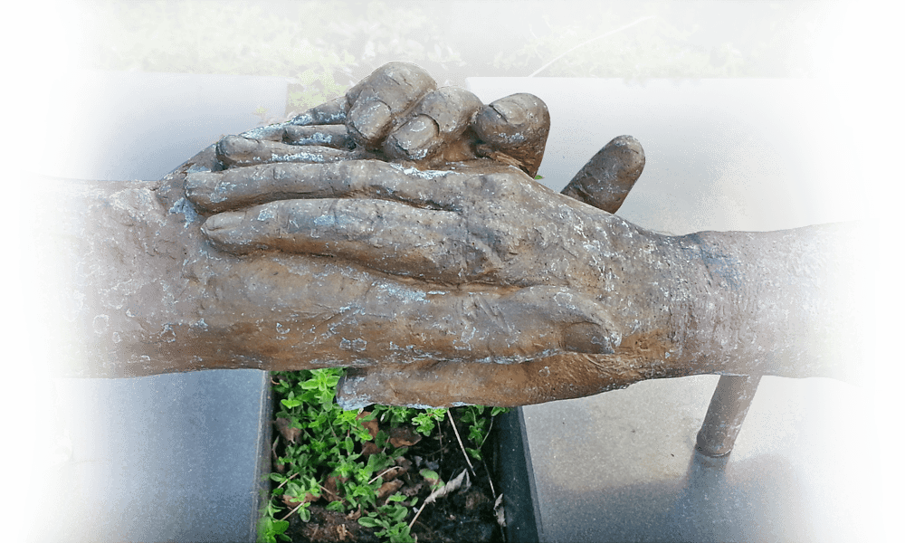 urnengraf brons met verstrengelde handen