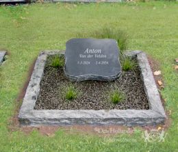 Kort grafmonument met ruwe omranding