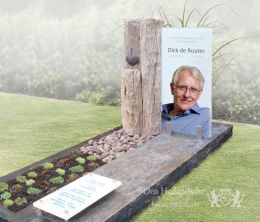 Modern glazen grafmonument met ruwe steensoorten