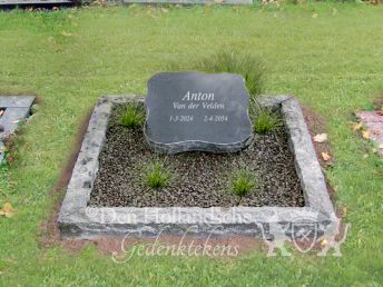 Kort grafmonument met ruwe omranding