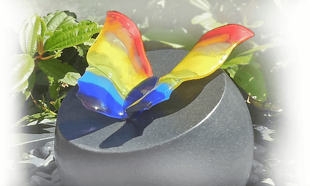 urnenmonument in eigen tuin met gekleurde vlinder op graf