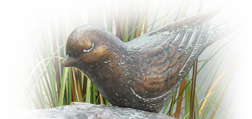 bronzen vogeltje op grafsteen