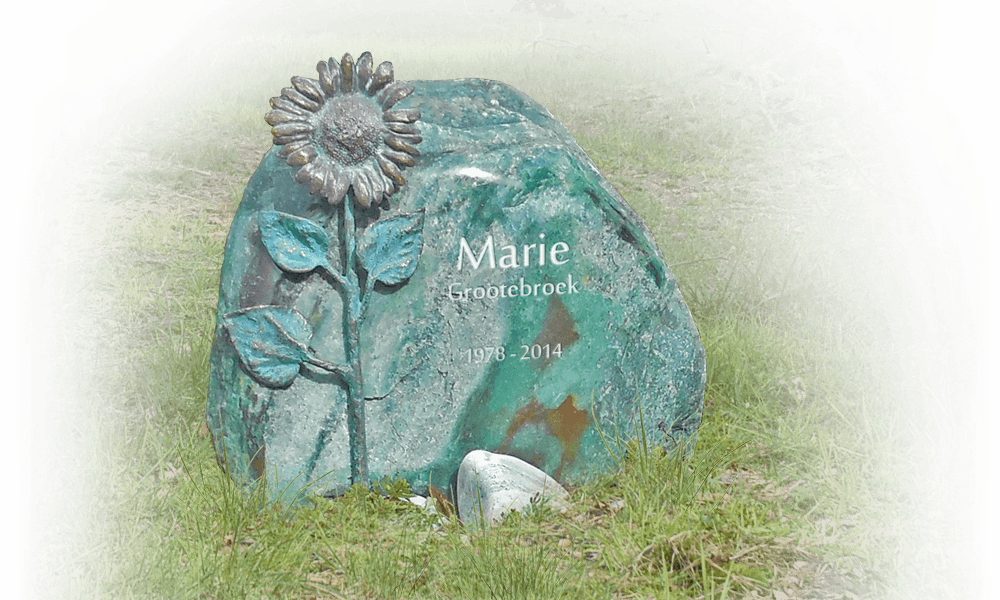 grafsteen natuurbegraafplaats zwerfkei met bronzen zonnebloem